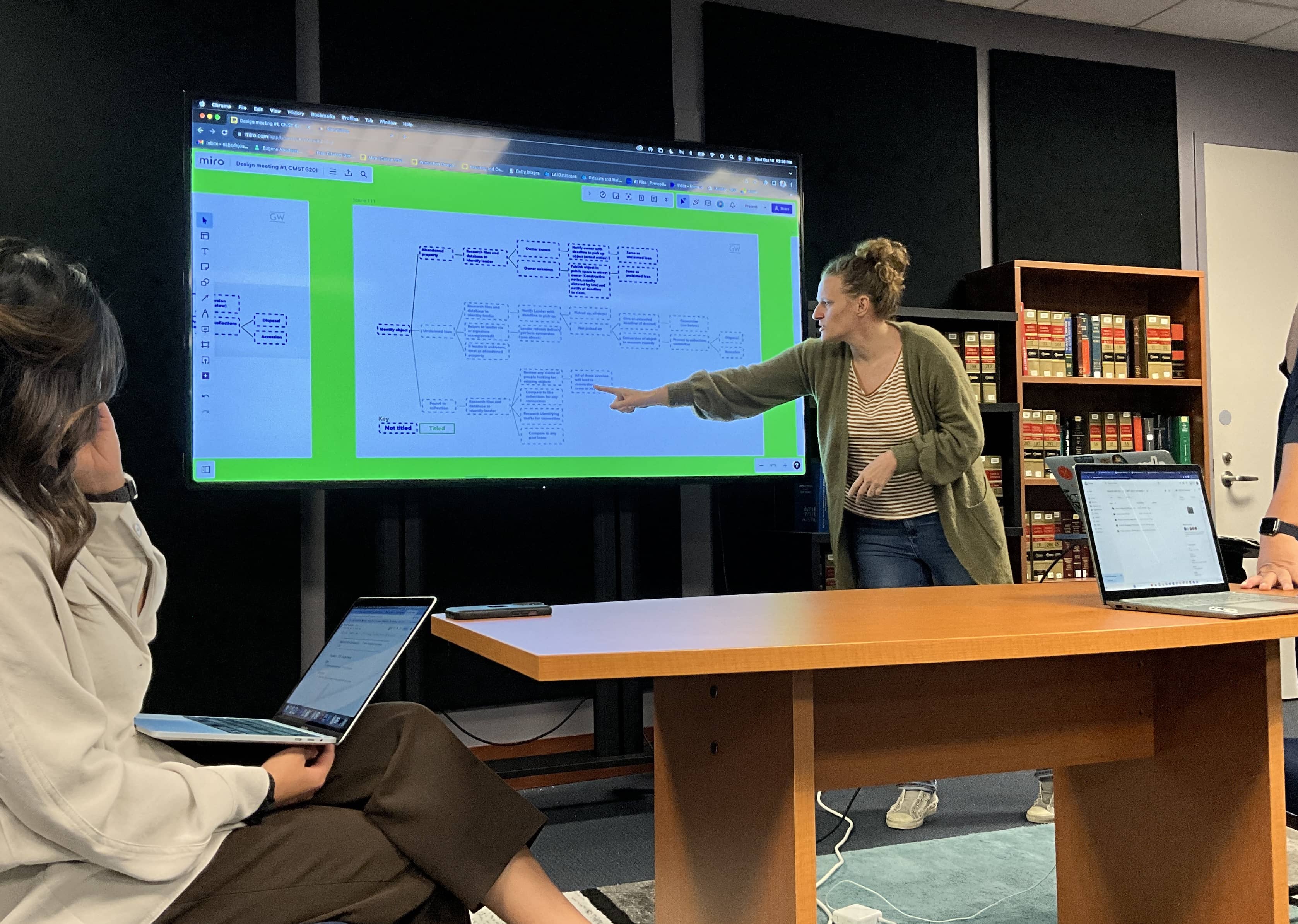 Picture of people in the studio discussing a diagram on a large TV monitor